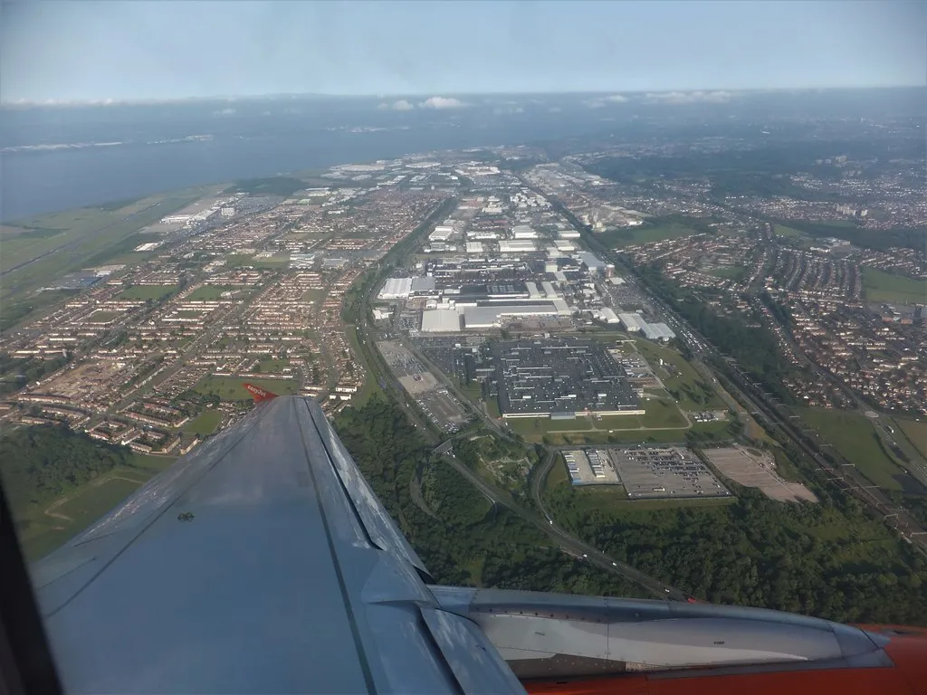 Aerial view of the Jaguar Land Rover Halewood plant beside the Mersey, seen from a plane window