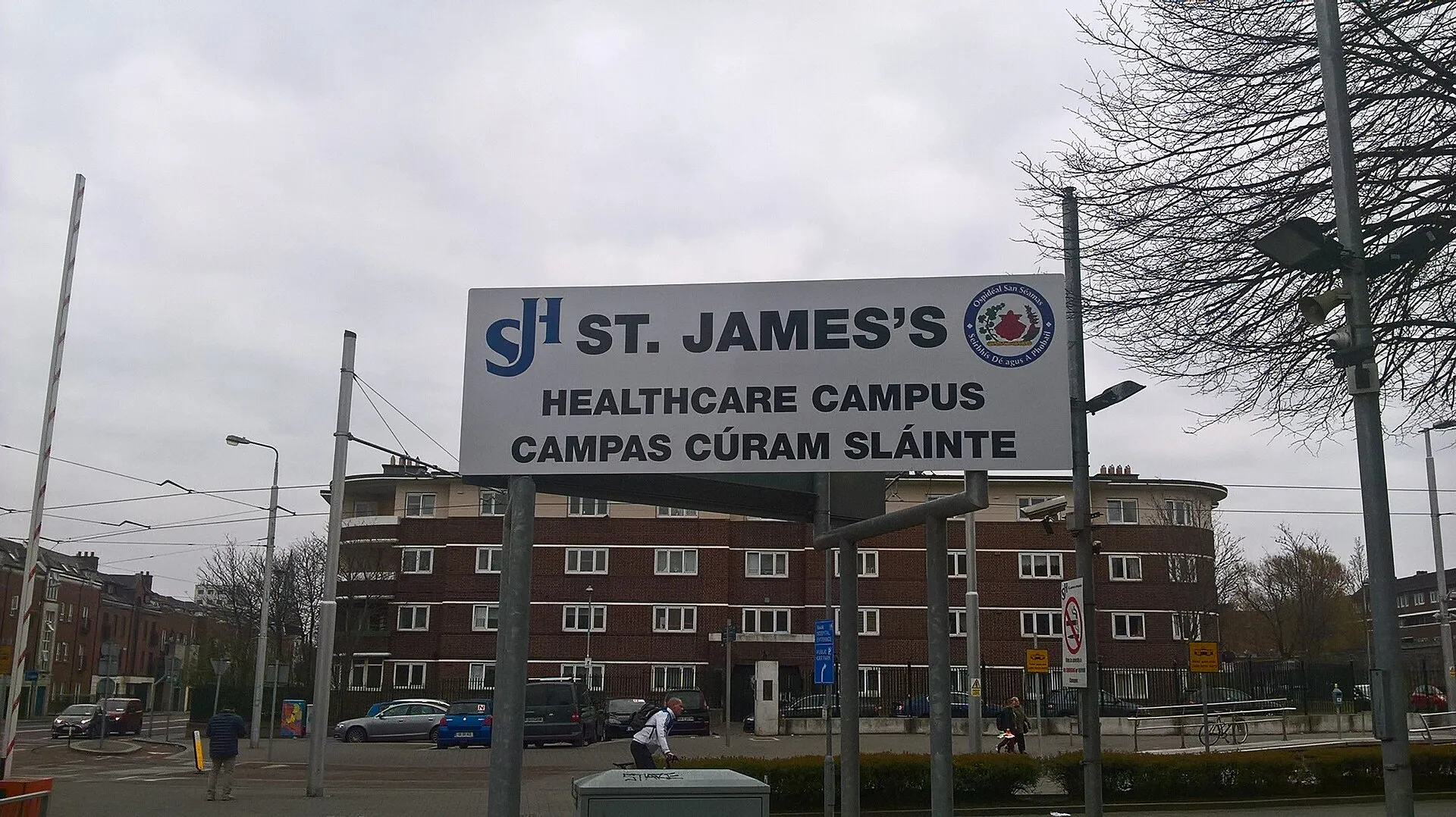 The St James’s Healthcare Campus sign in English and Irish in front of a red-brick hospital building